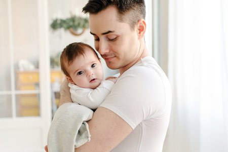 Happy father standing with baby in armsの写真素材