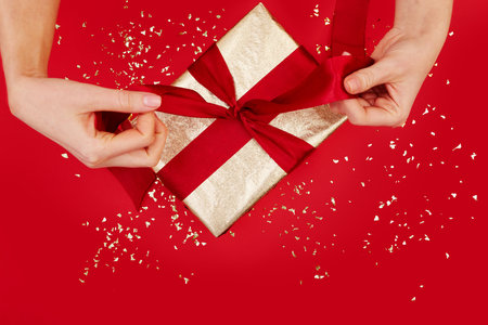 Beautifully Wrapped Gift Adorned with a Charming Red Ribbon on a Festive Background