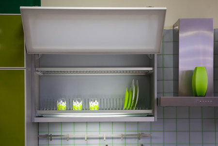 kitchen cabinet with green cups and dishesの写真素材