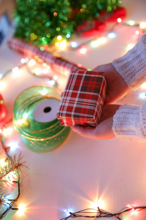 The girl packs the Christmas gifts in beautiful paper