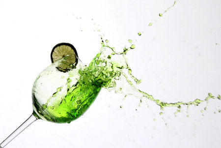 Lime juice with splashes is poured into a glassの写真素材