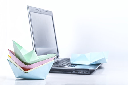 Photo of paper ships against the laptopの写真素材