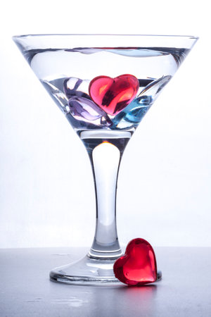 photo of a glass of the martini decorated with multi-colored heartsの写真素材