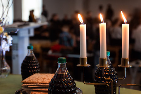 Holy communion with bread, vine, candles and blurry background