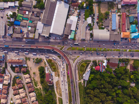 Crossing highway in rural area from a green plantation from a birds eye view in Thailand, top view