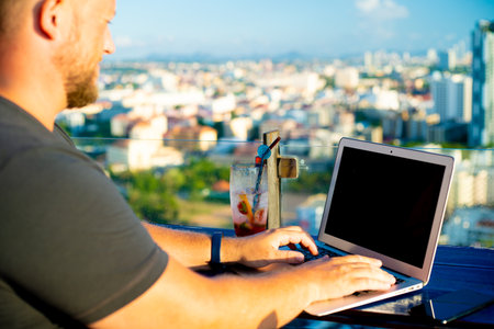 man working on a computer in a cafe with a beautiful viewの写真素材