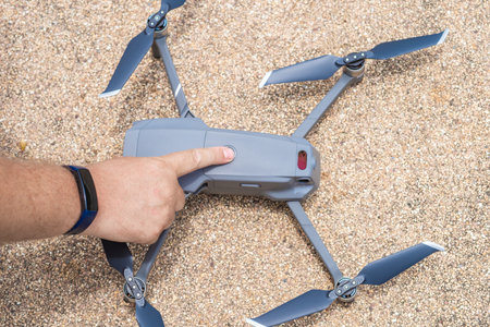 Male hand presses the button to launch the drone for flight, close-upの写真素材
