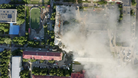 The roof of a residential house is burning. firefighters extinguish a fire on the roof of a residential high-rise building.の写真素材