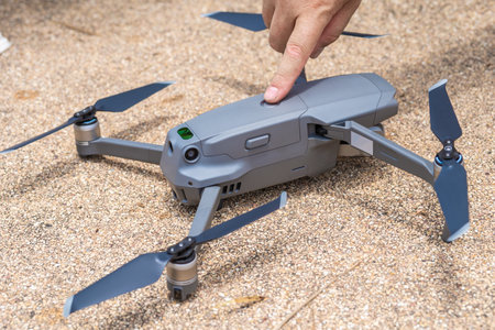 Male hand presses the button to launch the drone for flight, close-up