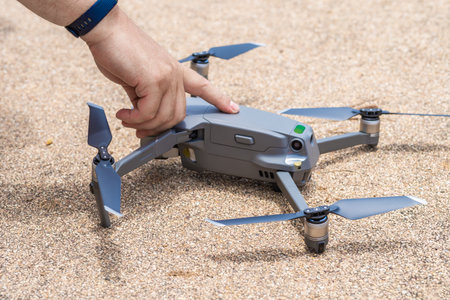 Male hand presses the button to launch the drone for flight, close-upの写真素材