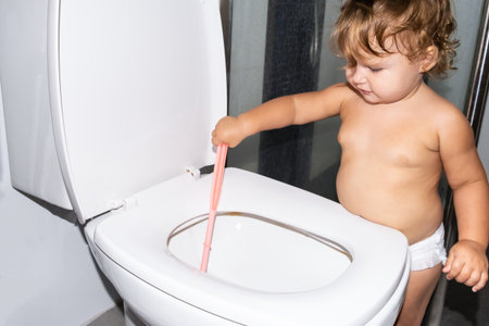 Child labor. Little girl cleans a toilet.の写真素材