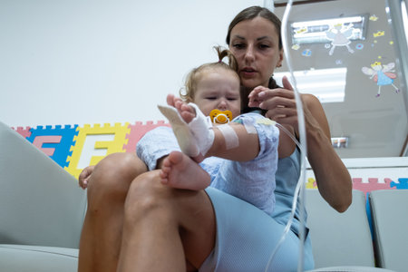 mom and crying little daughter in the hospital. Little girl is injected.の写真素材