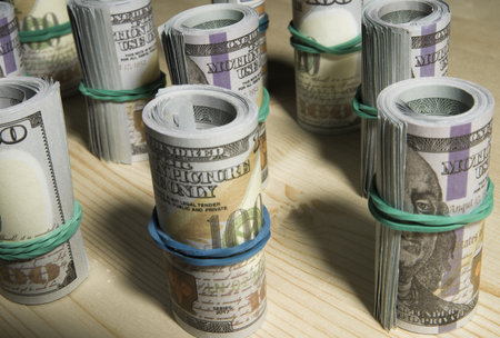 A lot of dollars money rolled up in a tube, on a black background