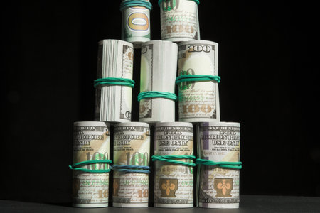 A lot of dollars money rolled up in a tube, on a black backgroundの写真素材