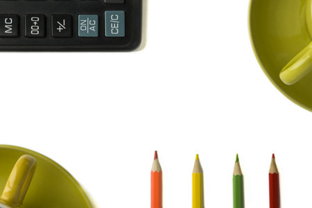 colored pencils, calculator key and part of a mug on an isolated white background. Copy space.の写真素材