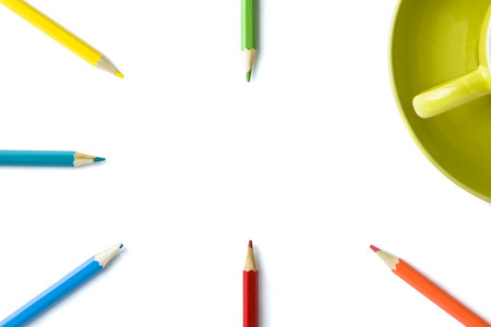 colored pencils and part of a mug on an isolated white background. Copy space.の写真素材