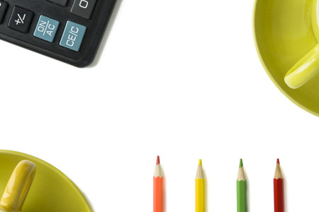 colored pencils, calculator key and part of a mug on an isolated white background. Copy space.の写真素材