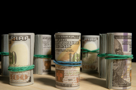A lot of dollars money rolled up in a tube, on a black backgroundの写真素材