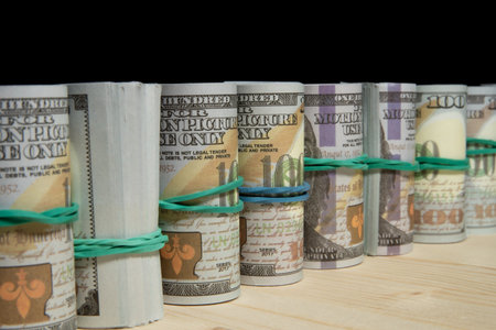 A lot of dollars money rolled up in a tube, on a black backgroundの写真素材