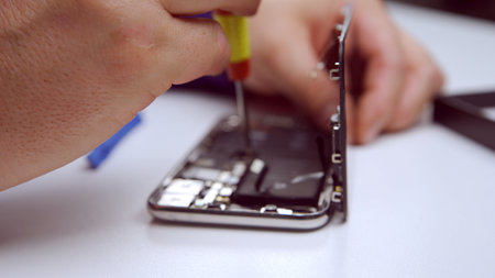 Phone repairman repairing a smartphoneの写真素材