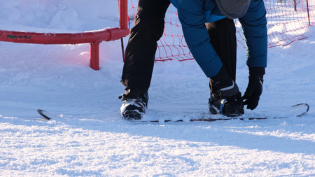 snowboarder puts on or removes a snowboard on a winter day, speaking downhillの写真素材