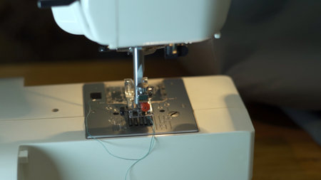Close-up of sewing machine needle rapidly moves up and down.