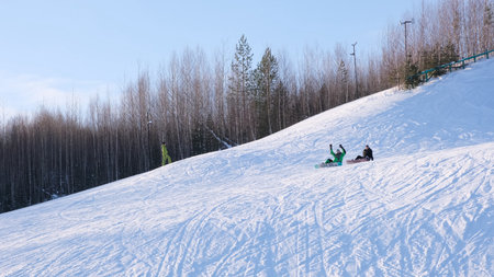 snowboarders sits on a mountainside, distant plan.の写真素材