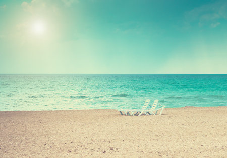 Two beach loungers under the bright sunの写真素材