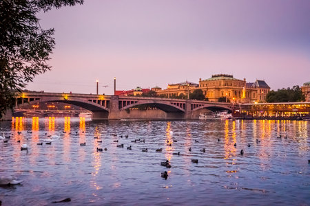 Manes bridge in Prague, Czech Republic at sunset. Ducks and swans on the riverのeditorial素材