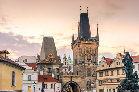 Malostranskie bridge towers (Lesser Town Bridge Tower) on the Charles Bridge in Prague, in the Czech Republic at sunset in autumn. Sculptures and lights on the Charles Bridgeの写真素材
