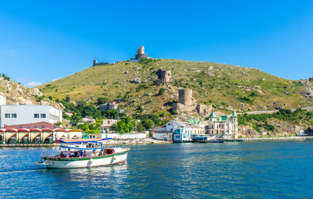 Balaklava Bay and the ruins of the ancient fortress Cembalo. Pleasure boats cruising along the bay. Balaklava, Crimea, Russiaのeditorial素材