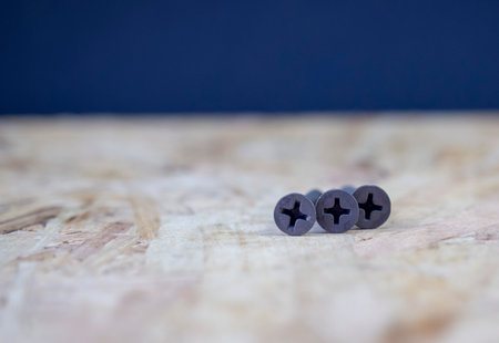Screws closeup on a light wooden surfaceの写真素材