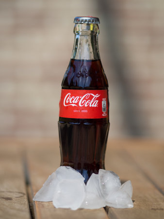 HOEILAART, BELGIUM - MAY 17 2017: A coca cola bottle surrounded by ice cubes.