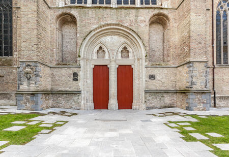 In Bruges there is a church with two doors in the middle of the cityの写真素材