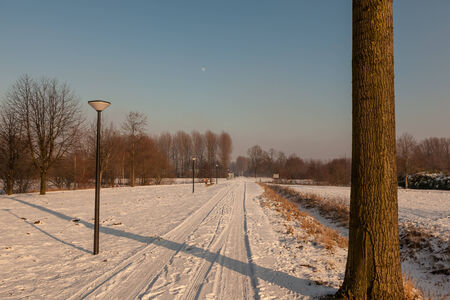 road whit sunrise and an beautiful moon in the winterの写真素材