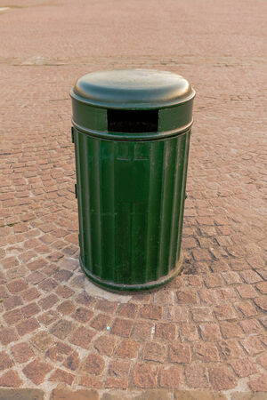 In the center stands a large metal garbage canの写真素材