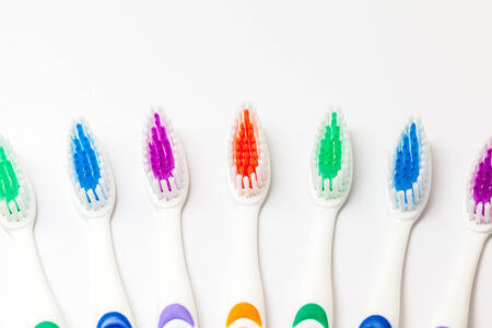 different colored plastic toothbrushes with white backgroundの写真素材