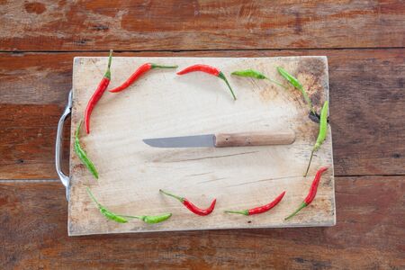 red and green pepper are hot and spicy vegetables on a cutting plant located with a knife potatoesの写真素材