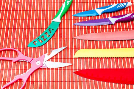 a set of knives and scissors on a bamboo mat