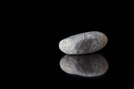 This boulder in close-up with reflection on a polished tileの写真素材