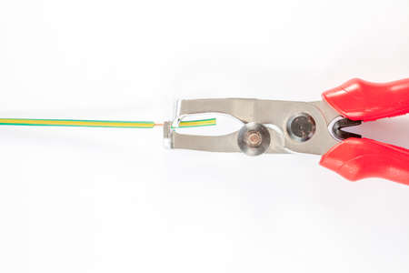 small nippers with black red handles on wooden boardの写真素材