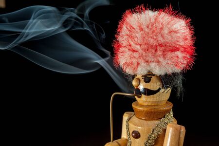 an smoking wood man with a big hat
