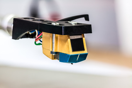 an arm of a record player with a steel needle that converts sound waves into musicの写真素材
