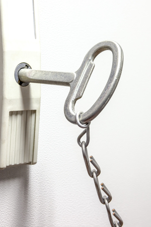 an iron chain hangs an fuse key in the keyholeの写真素材