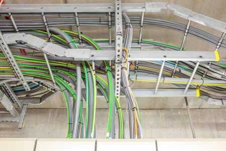electric cables with yellow and green earth cable coming out of an electric board