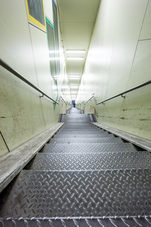 in a big city, there's a metal staircase in a tunnel just below a large riverの写真素材