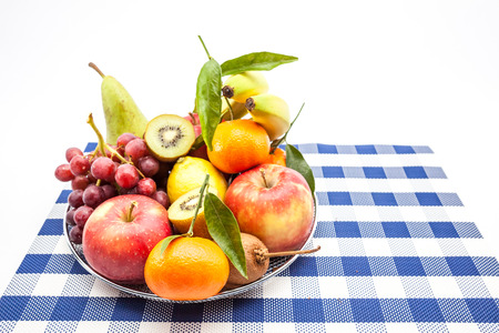 iron fruit basket with different fruits like apples, bananas, pears, grapes,kiwiの写真素材