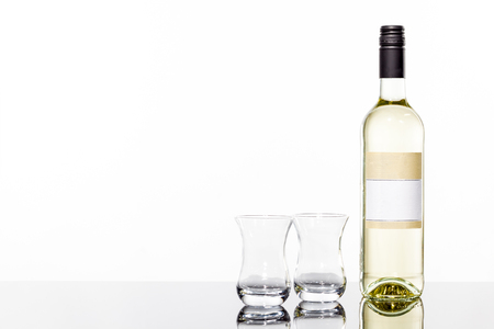 an white wine bottle and two drinking glasses with reflectionの写真素材