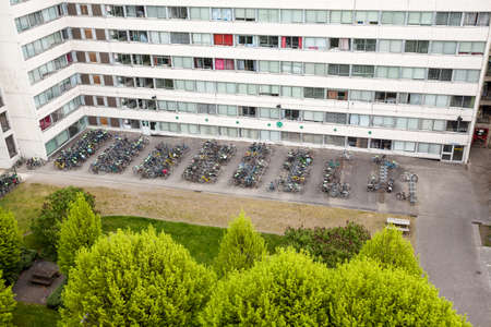 Bicycle parking for a tall building next to a park with trees