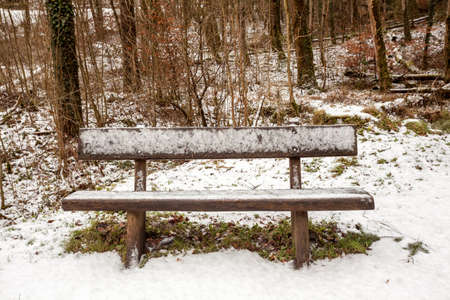 The snowy bench along the road in the mountainsの写真素材